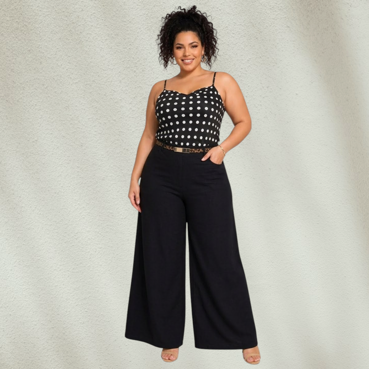 Purple Lola's Block plus size model wearing a black polka dot spaghetti strap tank top tucked into wide leg pants.