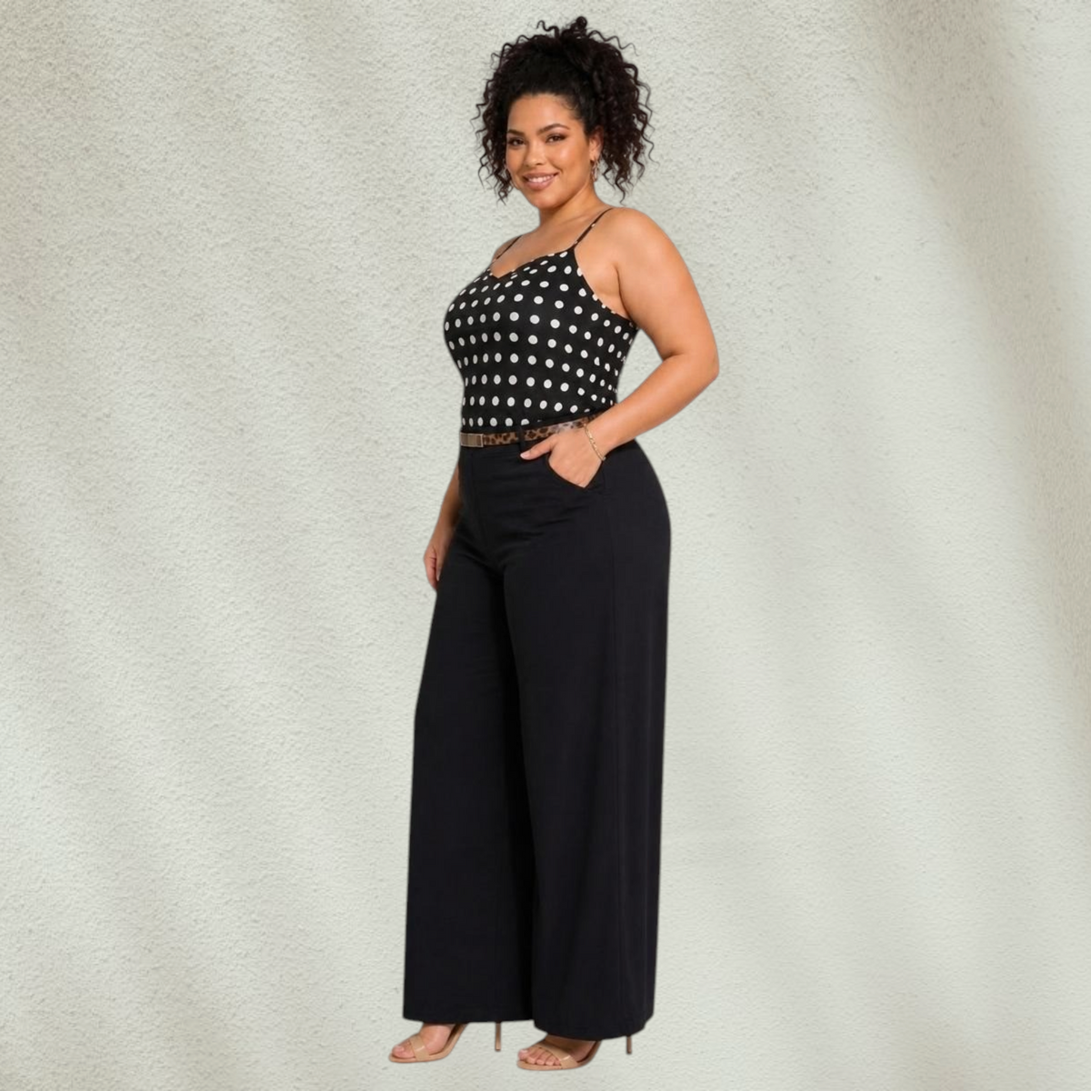 Plus size model wearing Purple Lola's Block Isabela polka dot tank top with black wide leg pants and heels.
